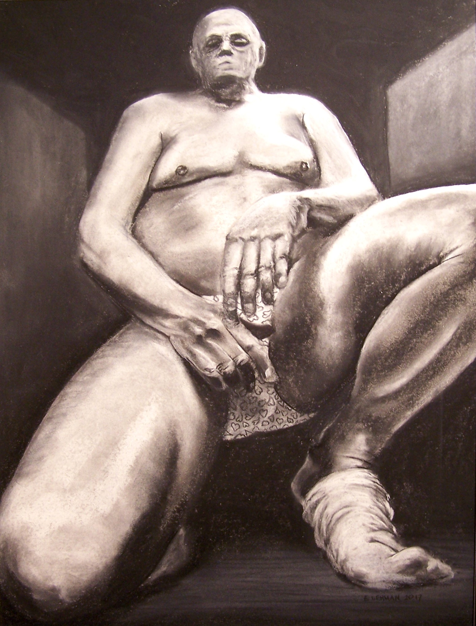 A charcoal drawing of a bald man. The figure is kneeling on his right knee with his left foot on the ground, elevated by the ball of his foot. His legs are much closer to the viewer and his head moves back into diminishing perspective. The head is smaller than is realistic, enhancing the perspective. He is resting his arms on his thighs and is nude except for underwear that has hearts on them. The hands cover most of his underware. The only other clothing he is wearing is a sock that is coming off of his left foot.
