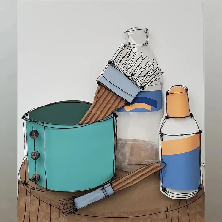 This piece utilizes teal, blue and orange paper, clear plastic, brown corrugated paper, and wire to create a still life of containers and brushes. The paper, plastic and cardboard are flat on the bottom surface and the wire is used to outline each object. The still life contains a water bottle with the clear plastic, a lidded can, a jar with a brush and a smaller brush all sitting on a circular surface.
