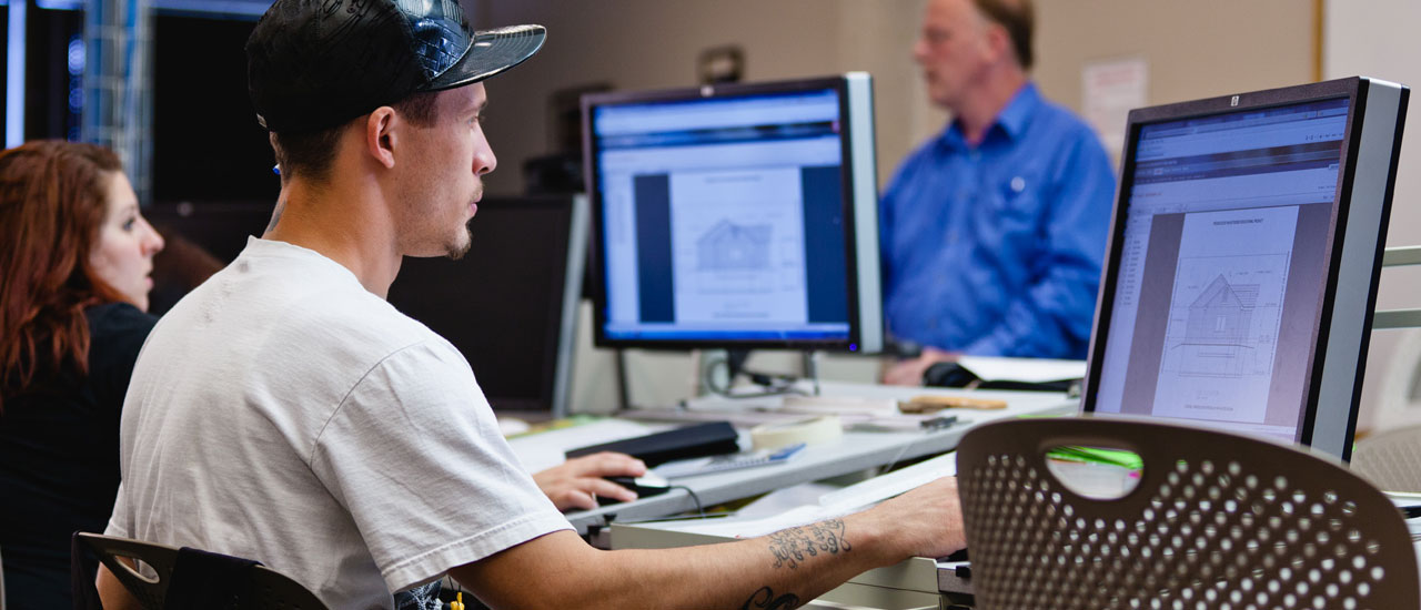 Students studying architectural designs on computers.